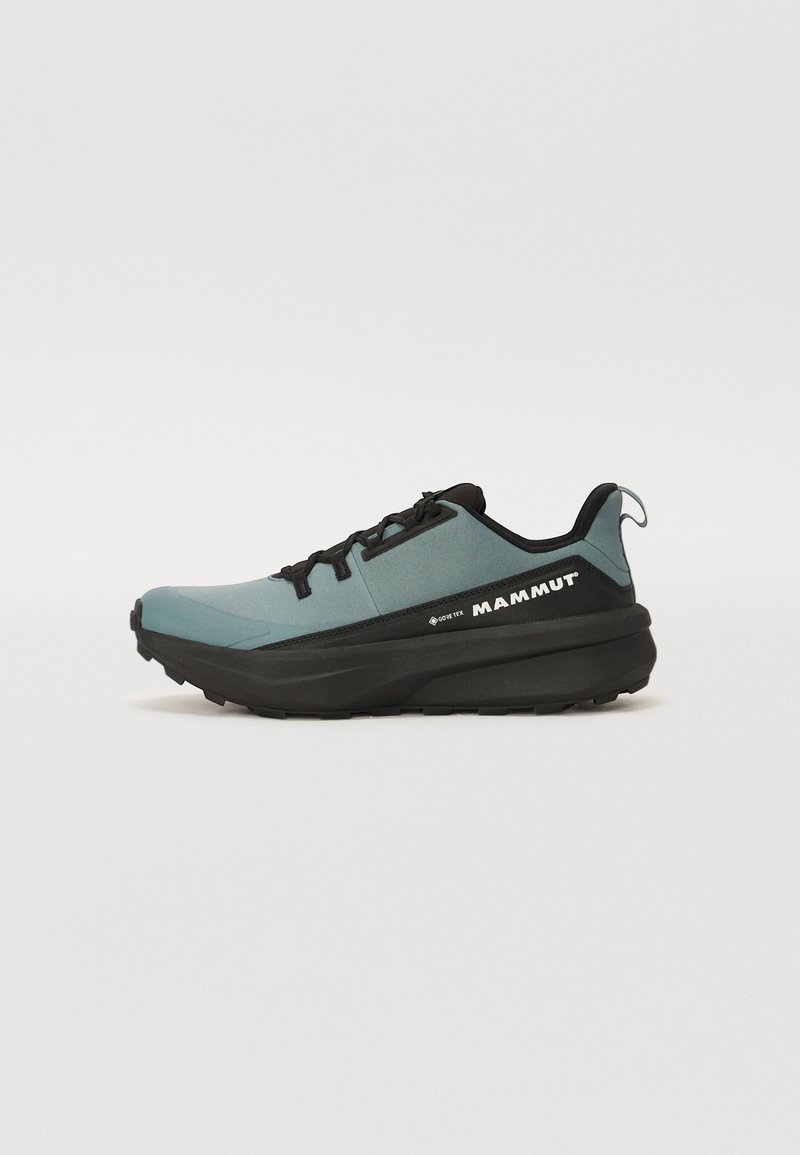 Mammut hardloopschoenen hebben een teal bovenwerk, zwarte accenten, een gestructureerde rubberen zool en een gestroomlijnd design. Gore-Tex materiaal voor waterdichtheid.