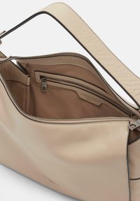 Sac à main en cuir beige avec fermeture éclair, doté d'une texture lisse et d'une doublure intérieure marron. Poches intérieures pour l'organisation.