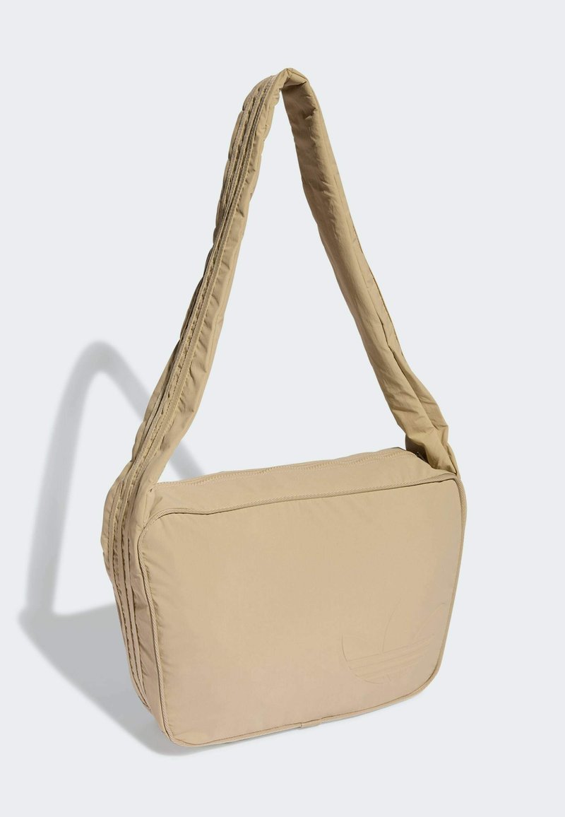 Beige gepolsterte Schultertasche mit flacher rechteckiger Form, breitem Tragegurt und geprägtem Logo-Detail auf der Vorderseite. Glatte, Nylon-Oberfläche.