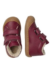 Scarpe in pelle bordeaux con suole in gomma color cammello. Presentano due cinturini in velcro e un morbido rivestimento in pelliccia beige per calore e comfort.