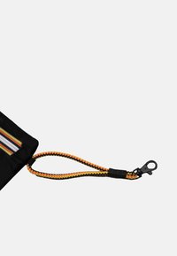 Borsa nera con dettaglio a righe e fascia da polso intrecciata attaccata in giallo, arancione e nero con chiusura in metallo nero.