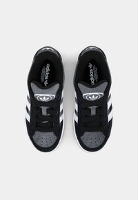 Svarta och grå Adidas-sneakers med vita ränder, i mocka och mesh-material, rundad tå och klassisk logotyp på tungan och häl.