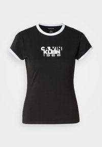 Black t-shirt with white ringer details, featuring a bold Calvin Klein 1968 graphic in the center. Made from cotton, short sleeves.