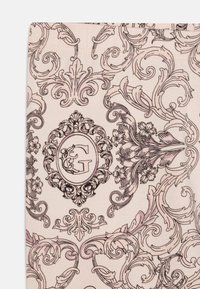 Tissu rose présentant un motif floral et de volutes détaillé en noir et mauve, avec un emblème central contenant les lettres "G" et "C."