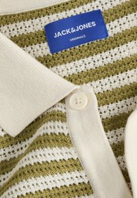 Knitted polo shirt with green and white stripes, featuring a textured pattern, beige collar, and a single white button. Brand tag visible.