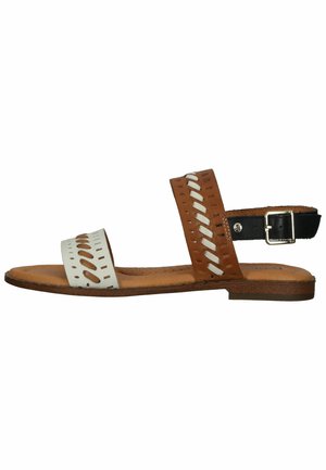 Sandalia de cuero marrón y blanco con dos correas anchas, diseño cortado y una correa de tobillo ajustable negra. Suela plana con interior marrón claro.