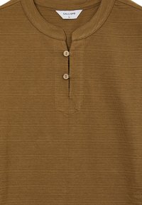 Maglietta henley marrone realizzata in tessuto testurizzato, con scollatura rotonda e due piccoli bottoni davanti. Motivo a righe orizzontali visibile.