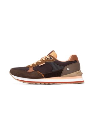 Zapatilla marrón y negra con parte superior de malla y gamuza, acentos naranjas y una suela gruesa blanca y marrón. Presenta detalles cosidos y texturas con patrones.