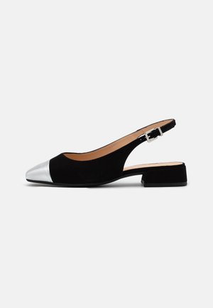 Chaussure slingback noire à petit talon avec un bout pointu argenté et une boucle carrée argentée sur la bride de la cheville.