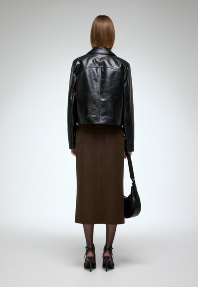 Black leather cropped jacket, brown pencil skirt, sheer black tights, strappy black heels, and a black shoulder bag.