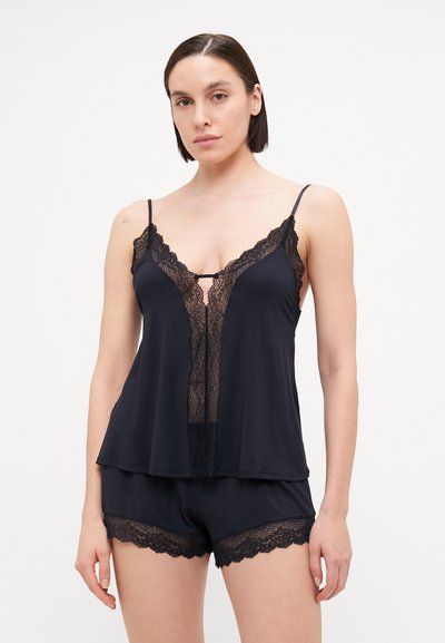Schwarzes Schlafset mit einem Trägershirt mit Spitze und einem Schlüssellochausschnitt, kombiniert mit passenden Shorts mit Spitzenrand. Weicher, fließender Stoff.