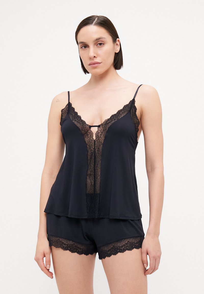 Black sleep set featuring a camisole with lace trim and a keyhole detail, paired with matching shorts with lace edges. Soft, flowing fabric.