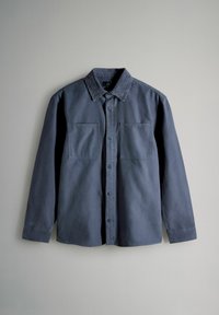 Donkerblauw overhemd met lange mouwen en knopen, voorzien van een corduroy kraag en twee borstzakken, getoond tegen een lichtgrijze achtergrond.