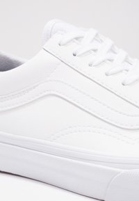 Weißer Sneaker mit glattem Leder-Obermaterial, abgerundetem Schuhspitze, flachen Schnürsenkeln und strukturiertem Gummisohle. Dekorative Seitennaht und Akzente.