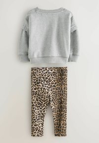 Grå sweatshirt med ribbade ärmslut och rundad halsringning, i kombination med leggings i svart och brunt leopardmönster som har en tajt passform och elastisk midja.