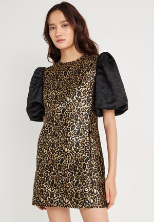 Šaty s leopardím potlačou vyrobené z lesklého zlatého a čierneho materiálu, krátky strih a čierne textúrované pufované rukávy. Majú okrúhly výstrih a podšívkový dizajn.