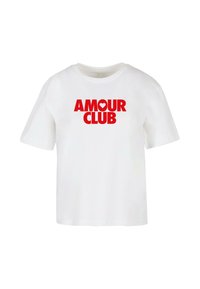 T-shirt en coton blanc avec un large texte graphique rouge "AMOUR CLUB" accompagné d'un symbole de cœur, à manches courtes et à coupe décontractée.