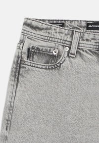 Jeans en denim gris avec un design classique à cinq poches, fermeture à bouton et détails légèrement décolorés, avec une texture douce.