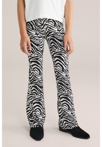 Zebramönstrade utsvängda byxor med svart och vitt mönster, tillverkade av mjukt tyg med en bekväm passform och sidofickor.