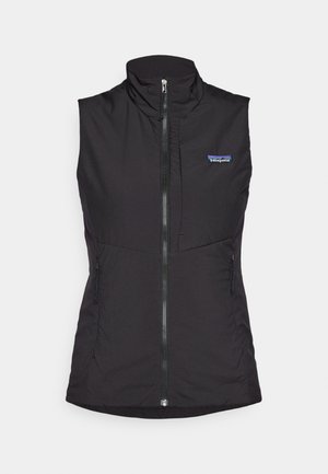 Crna bezrukavna majica, s visokim ovratnikom, prednjim zatvaračem i dva bočna džepa, izrađena od glatkog, laganog materijala. Vidljiv logo Patagonia.