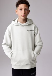 Sudadera con capucha gris claro con bolsillo frontal, cordón ajustable y logo negro "ALLSAINTS" en el pecho. Material de algodón suave y texturizado.