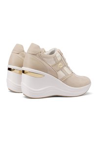 Sneaker platform beige con una combinazione di texture liscia e scamosciata. Presentano dettagli dorati e una suola bianca curvata per un'altezza aggiuntiva.