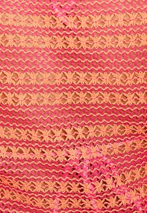Tissu au crochet rose et orange avec des rangées horizontales de motifs floraux et de mailles créant un effet de dentelle texturé.