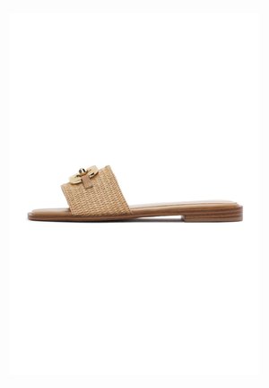 Flat slide sandal with woven beige strap and gold-tone circular buckle detail on wooden sole.