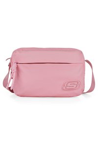 Bolso bandolera rosa hecho de nylon suave, con un bolsillo frontal con cremallera y un logotipo desbastado en el lateral. Incluye una correa ajustable.