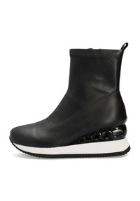 Botín negro de cuero hasta el tobillo con parte superior suave, entresuela blanca y un elegante detalle en cadena negra brillante en el tacón cuña, que presenta una suela texturizada.