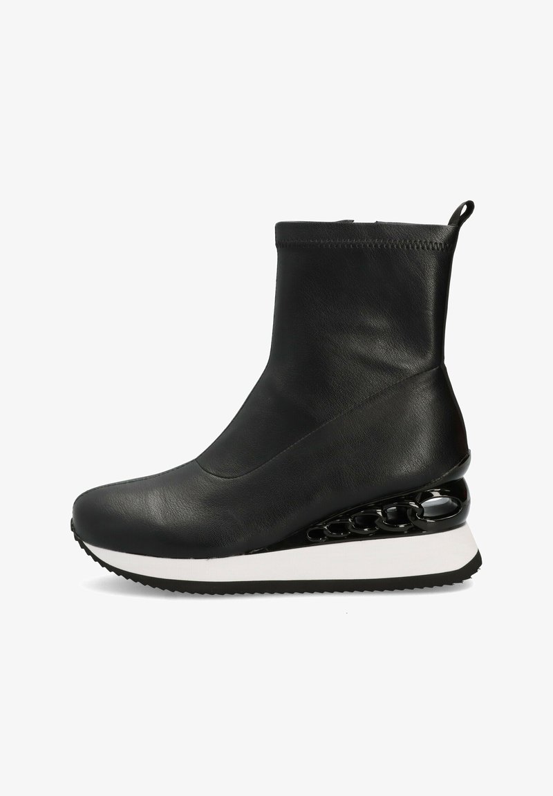 Botín negro de cuero hasta el tobillo con parte superior suave, entresuela blanca y un elegante detalle en cadena negra brillante en el tacón cuña, que presenta una suela texturizada.