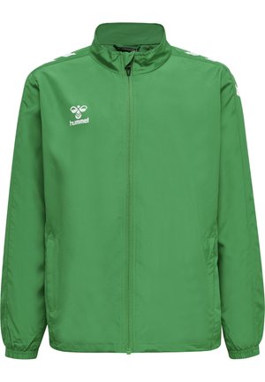 Veste légère verte en tissu lisse et résistant à l'eau. Comprend une fermeture éclair intégrale, un col montant et un logo blanc sur la poitrine gauche.