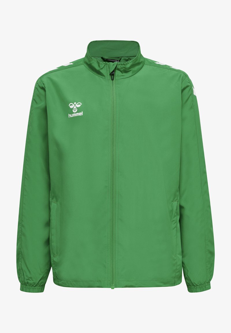 Grön lättviktsjacka gjord av slät, vattenavvisande tyg. Har en hel dragkedja, hög krage och vit logotyp på vänster bröst.