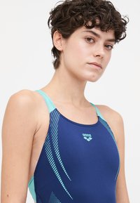 Navy swimwear featuring light teal straps and diagonal striped accents. Made of smooth fabric, designed for comfort and performance.