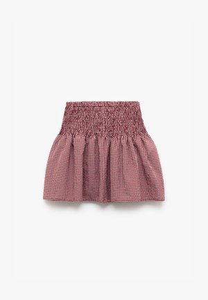 Blusa de cuadros rojos y blancos con corsé fruncido y dobladillo acampanado, que presenta una tela texturizada y un diseño liviano.