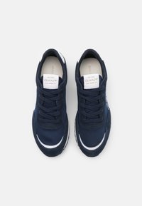 Para granatowych sneakersów GANT z białymi akcentami, związaną sznurówką, widziana z góry na jednolitym białym tle.