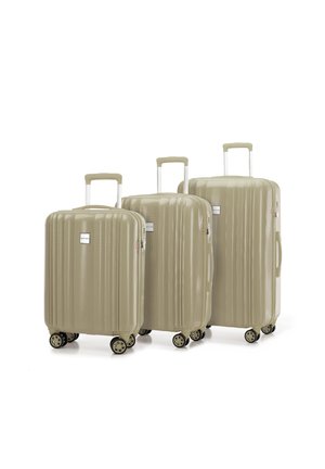 Tres maletas rígidas de color beige con un diseño estriado, asas telescópicas y cuatro ruedas cada una. La maleta más grande está enfrente.
