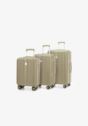 Drei beigefarbene Hartschalenkoffer mit einem gerippten Design, Teleskopgriffen und jeweils vier Rädern. Der größte Koffer befindet sich vorne.