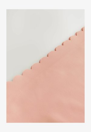 Tissu couleur pêche avec une surface texturée, présentant un détail à bord festonné sur un côté. Texture lisse et douce.