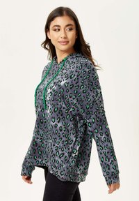 Gray hoodie with a green and black leopard print pattern, featuring a front pocket and drawstring hood. Soft texture, long sleeves.
