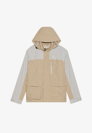 Veste beige avec des accents gris, une capuche, une fermeture éclair à l'avant, deux grandes poches et une petite poche zippée sur la poitrine. Légère, texture lisse.