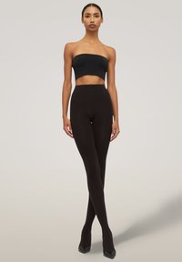 Leggings neri a vita alta realizzati in un tessuto morbido ed elastico, con un design senza cuciture e una silhouette aderente.