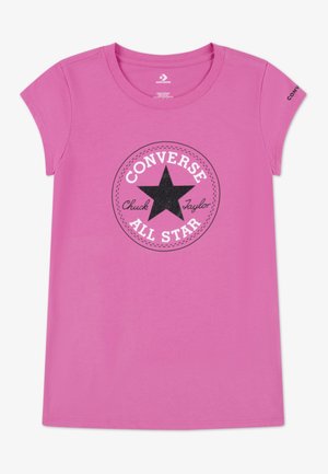 Różowy t-shirt z krótkim rękawem i okrągłym dekoltem, z czarną gwiazdą i logo "Converse All Star Chuck Taylor" umieszczonym na środku z przodu.