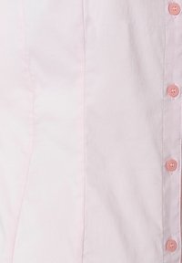 Light pink shirt featuring a smooth texture, button-down front with round, pink buttons, and subtle seams on the side.