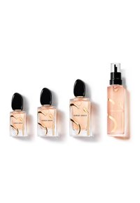 Quatre flacons de parfum Giorgio Armani avec bouchons noirs et accents dorés, disposés du plus petit au plus grand sur un fond blanc.