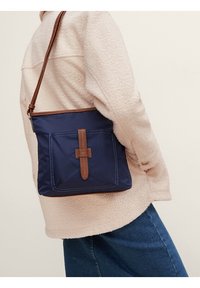 Borsa a spalla in nylon blu navy con forma rettangolare, dettagli in pelle marrone, tasca frontale e chiusura semplice con fibbia.