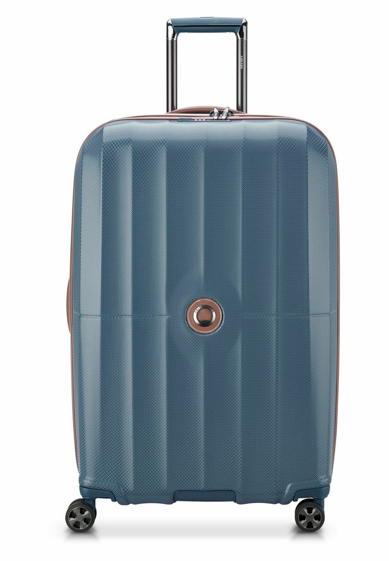 Valigia rigida di colore blu scuro con superficie testurizzata, caratterizzata da scanalature orizzontali, manico estraibile e quattro ruote per la mobilità.