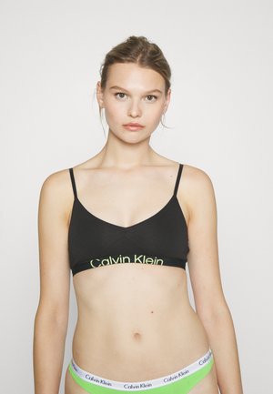 Zwarte bralette met dunne bandjes, voorzien van een groene Calvin Klein-logo op de band. Soepele stof met een V-hals ontwerp.