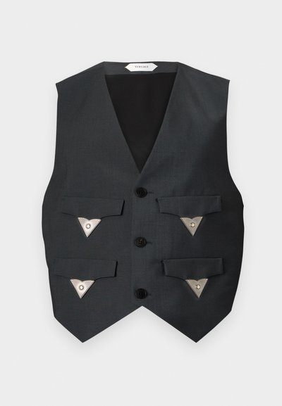 Gilet noir sur mesure avec quatre poches avant à rabat, chacune fermée par un bouton triangulaire argenté, et trois boutons noirs au centre.