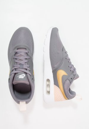 Grå og guld Nike Air-sneakers med mesh og læder overdel, synlig Air-sål enhed og hvid gummiydersål, vist fra top- og sidevinkler.